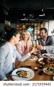 Happy Business People Celebrating Their Success And Toasting With Wine During A Lunch In Restaurant.