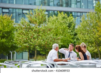 Happy Business People In A Coffee Shop Talking To Each Other Outdoors