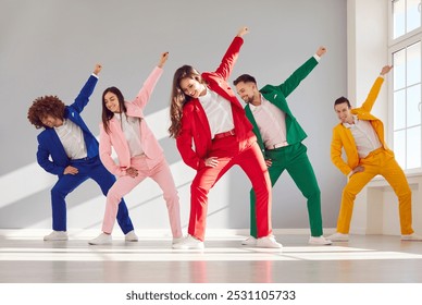 Happy business people dancing together in colorful suits. This vibrant group of dancers showcases the happiness and camaraderie found in team celebration, party and dynamic dance show. - Powered by Shutterstock