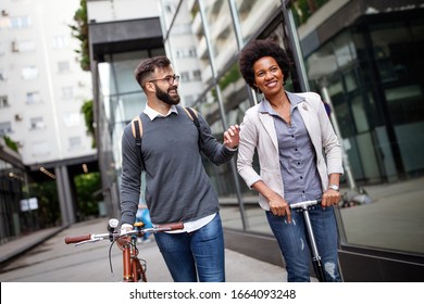 Happy business people going to work with bicycle, electric scooter on urban street - Powered by Shutterstock