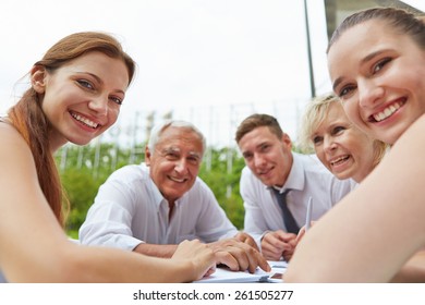 Happy Business People Sitting Together During Meeting Outdoors On A Table