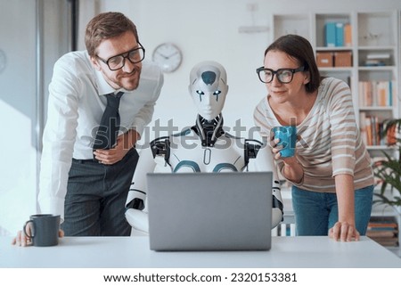 Happy business people supervising an AI robot working in the office
