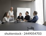 Happy business team having pleasant talk in contemporary board-room. Seminar or corporate training event led by smiling mature 50s business coach, share knowledge, explain strategy to staff members