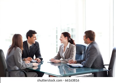 Happy Business Team Talking Together During A Meeting Sitting At A Table