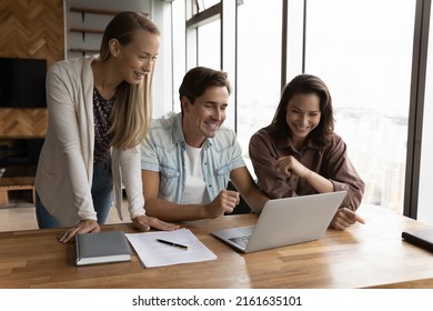 Happy Business Team Watching Online Training Or Virtual Presentation On Laptop At Workplace. Group Of Employees Making Video Conference Call From Office, Working On Project Design Together. Teamwork