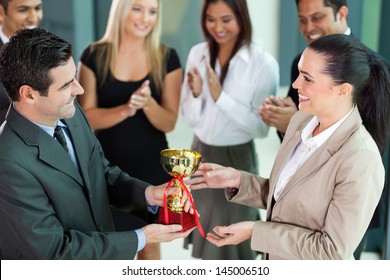 happy business team winning a trophy - Powered by Shutterstock