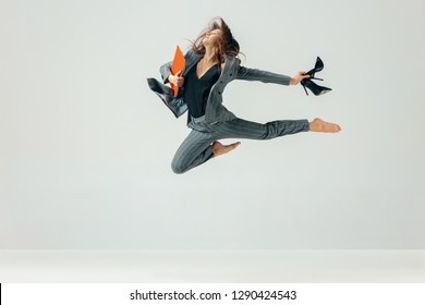 Happy business woman dancing and smiling in motion isolated over white studio background. Human emotions concept.  The businesswoman, office, success, elegance, grace, performer, flexible concepts