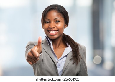 Happy business woman giving thumbs up
