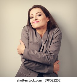 Happy Business Woman Hugging Herself With Closed Eyes And Natural Emotional Face. Love Concept Of Yourself. Toned Portrait