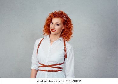 Happy business woman smiling. Cheerful girl in formal wear white shirt red head ginger curly hair looking at you smile on face isolated on gray background wall. Positive emotions, human expression
