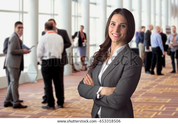 Happy business woman standing in crowd at\
workshop event with big genuine natural\
smile