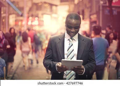 Happy businessman checking his tablet