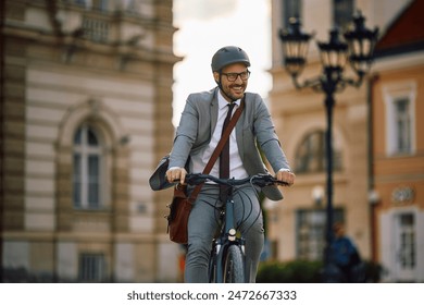 Happy businessman cycling through the city. Copy space.  - Powered by Shutterstock