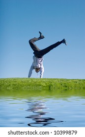 Happy Businessman Doing Summersault On Grass