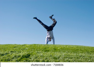 Happy Businessman Doing Summersault On Grass