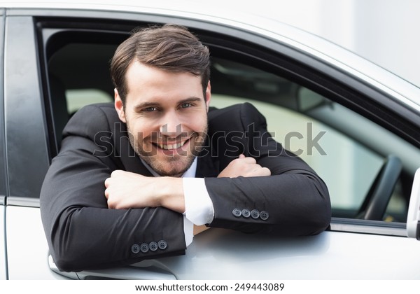 Happy\
businessman in the drivers seat in his\
car