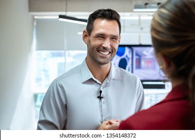 Happy Businessman During Corporate Interview With Female Journalist. Manager Answering Question In Office. Young Woman At Work As Reporter Interviewing Business Man During Presentation