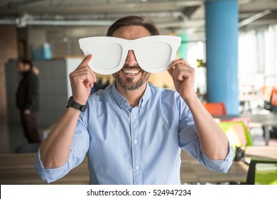 Happy Businessman With Funny Glasses On Showing To Camera. Handsome Happy Man Joking During Work. Break Time Concept.