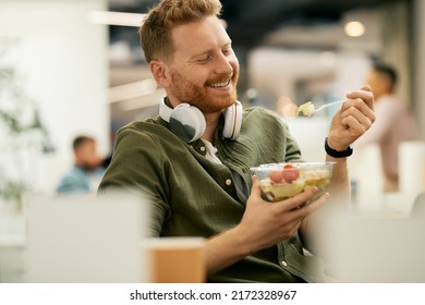 Happy businessman having a healthy meal during lunch break at work.