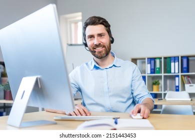 Happy Businessman With Headset For Video Call Working In Modern Office, Smiling Man Looking At Computer Monitor