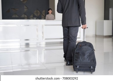 Happy Businessman In Hotel Check In At Reception Or Front Office Being Given Key Card. Classy Welcome Concept. Setup Studio Shooting.