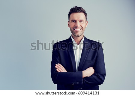 Happy businessman isolated - handsome man standing with crossed arms