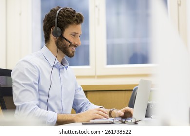 Happy Businessman In The Office On The Phone, Headset, Skype