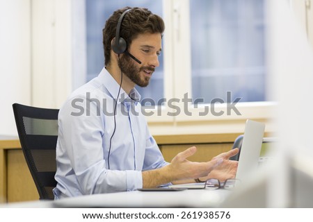 Happy Businessman in the office on the phone, headset, Skype