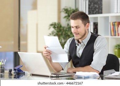 Happy Businessman Reading A Letter Sitting In A Desk At Office