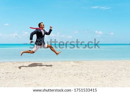 Happy businessman running away from office work on the beach. Summer vacation concept.