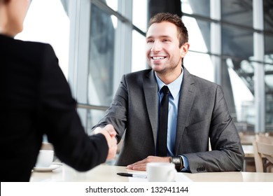 Happy businessman shaking hand with businesswoman. - Powered by Shutterstock