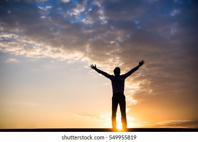 Happy Businessman show hand up for successful at beautiful sunset time. - Powered by Shutterstock