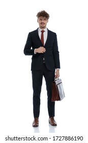 Happy Businessman Unbuttoning His Jacket And Holding Briefcase While Wearing Suit And Standing On White Studio Background