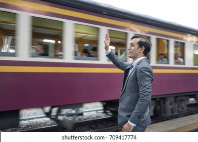 Happy Businessman Waving His Hand To Friend On Train.Send Colleagues Back Home.