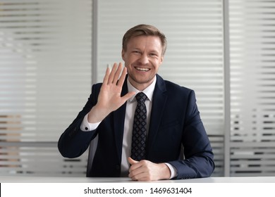 Happy Businessman At Workplace Wave Looking At Camera Talking On Video Call Or Conversation With Business Partner, Smiling Male CEO Or Executive Greeting Shooting Recording Tutorial In Office