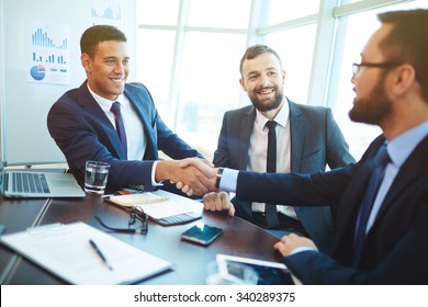 Happy businessmen handshaking after negotiation in office - Shutterstock ID 340289375