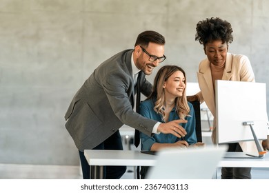 Happy businesspeople laughing while collaborating on a new project in an office. - Powered by Shutterstock