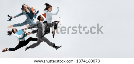 Happy businesswoman and african man dancing in motion isolated on white studio background. Flexibility and grace in business. Human emotions concept. Office, success, professional, happiness