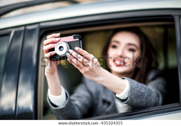 Happy businesswoman, bank and insurance\
worker. Tourist people concept - beautiful successful woman make\
photo on camera outside the car. Stylish\
purse.
