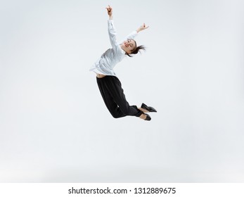 Happy businesswoman dancing and smiling in motion isolated on white studio background. Flexibility and grace in business. Human emotions concept. Office, success, professional, happiness, expression