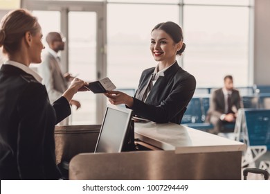 Happy Businesswoman Giving Passport And Ticket To Staff At Airport Check In Counter