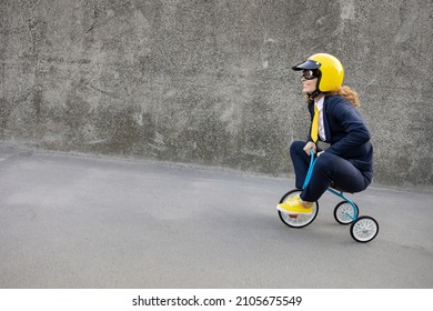 Happy businesswoman going to work. Funny young woman riding retro bike outdoor. Back to work, start up and career development concept