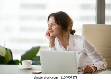 Happy businesswoman looking away satisfied with good new job enjoying business success and wellbeing working in office, smiling woman boss feeling motivated dreaming thinking about future goals