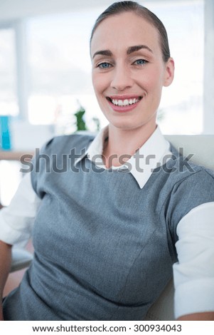 Happy businesswoman looking at camera in office