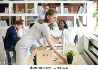 Happy Businesswoman New Employee Unpacking Box With Personal Belongings In Office, Smiling Female Hired Worker Newcomer Intern Unbox Stuff At Workplace Desk Got New Job On First Day At Work Concept