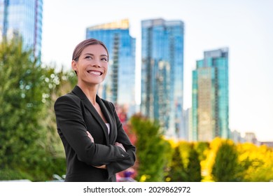 Happy Businesswoman Portrait Of Young Asian Executive Wearing Professional Suit Confident Outside Office Buildings Looking Up Aspirational. Ethnically Diverse Successful Woman At Her Job.