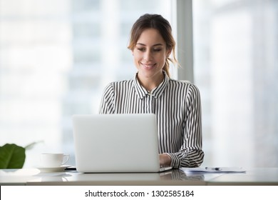 Happy Businesswoman Professional Worker Working Online Doing Job On Laptop At Desk, Smiling Female Employee Executive Typing Message Using Corporate Computer Software For Business In Modern Office