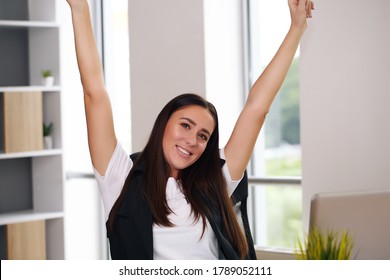 Happy Businesswoman With Raised So Hand Gesture Reading Letter On Desk In Front Of Laptop. The Businessman Is Satisfied With The Good News From The Correspondence.