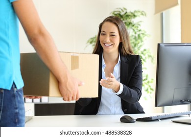 Happy businesswoman receiving a package sitting on a desk at office