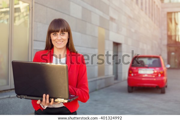 Happy businesswoman. Saleswoman with laptop\
on the office building\
background.